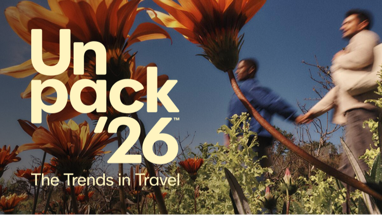 People holding hands and walking past large orange flowers with a blue sky in the background