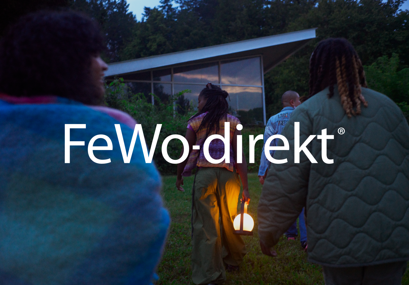 Eine Gruppe von Menschen, die auf ein Haus zugehen; einer von ihnen hält eine Lampe in der Hand. Im Vordergrund ist das Vrbo-Logo abgebildet.