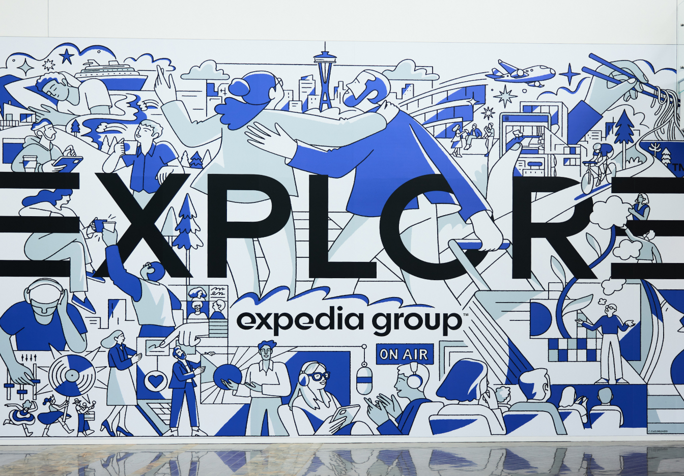 Explore wall mural with large stylized letters and travel-themed drawings.