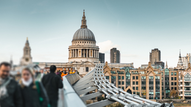 The dome of St. Paul’s Cathedral in London, England, seen from the Millennium Bridge as pedestrians cross the bridge in the foreground