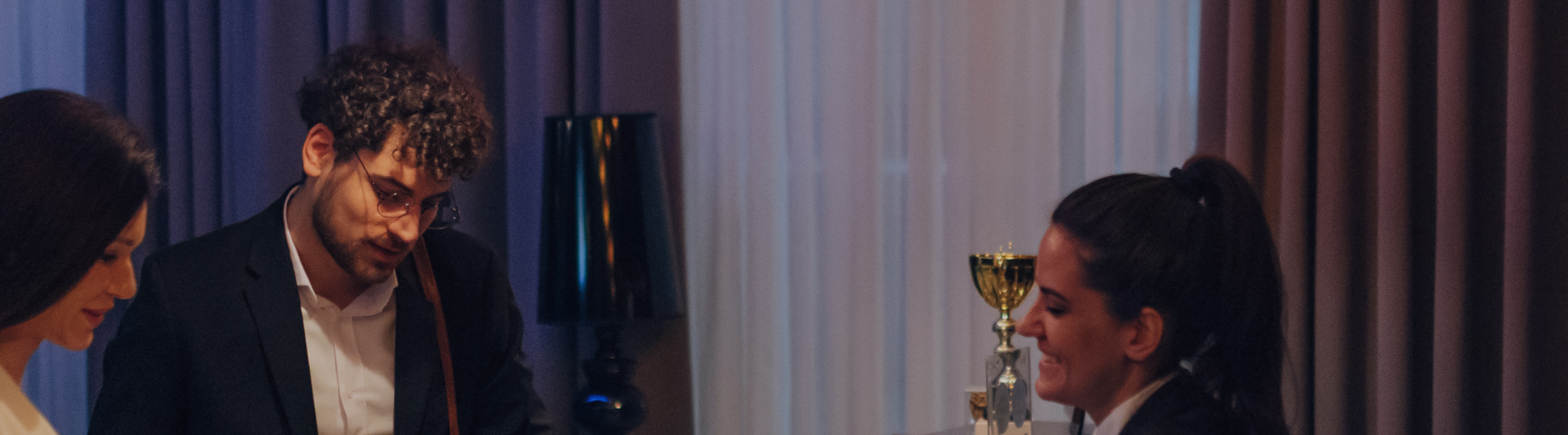 Dos conserjes de hotel ayudan a huéspedes por teléfono en la recepción.