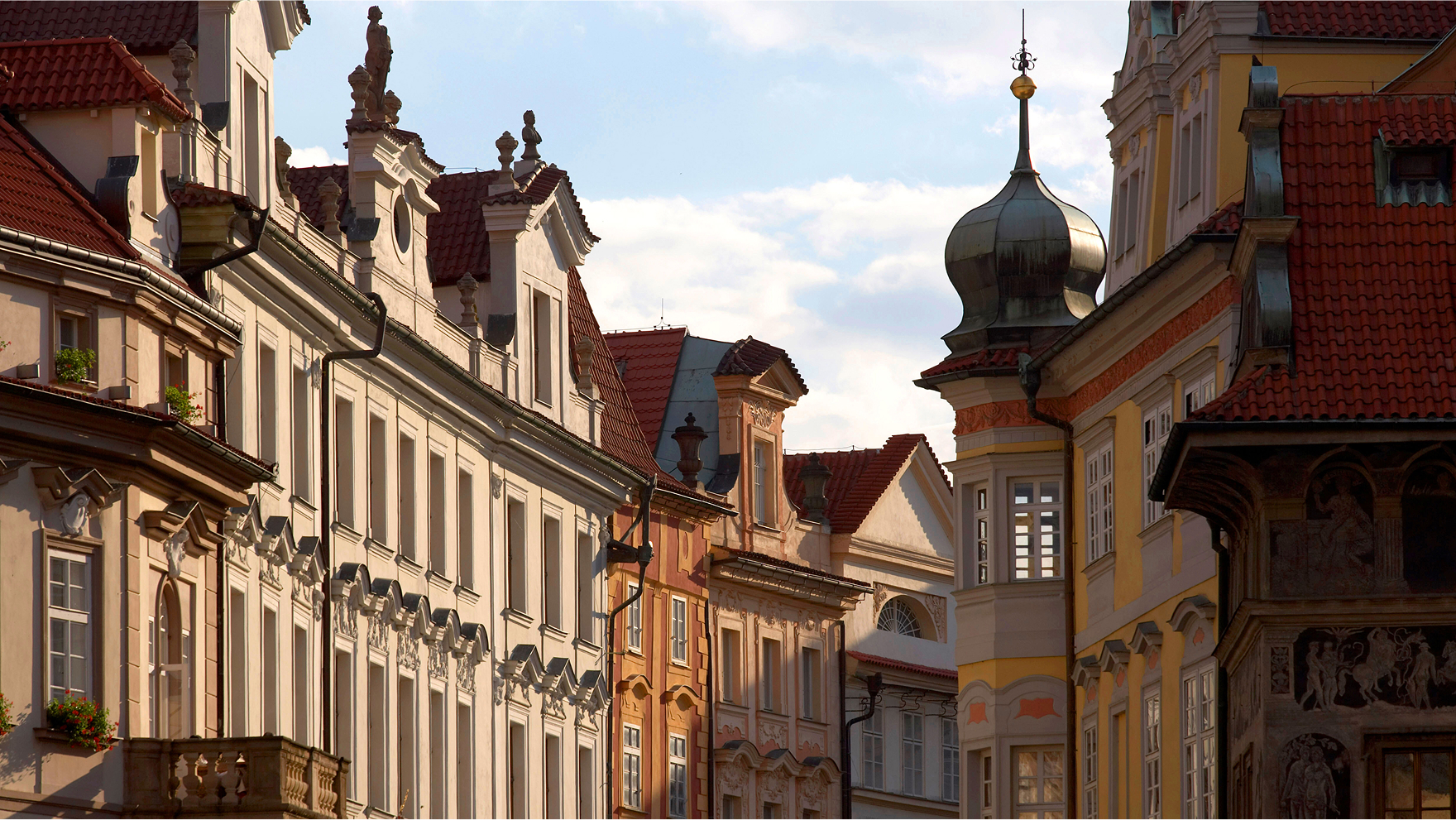 Decorative multi-story hotel with towers and intricate architectural details in warm sunlight.