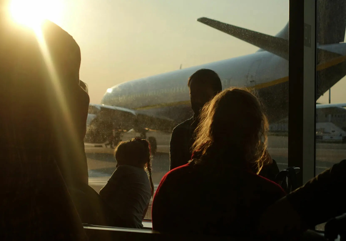 People waiting on the airport to onboard the airplane with a beautiful sunlight shining