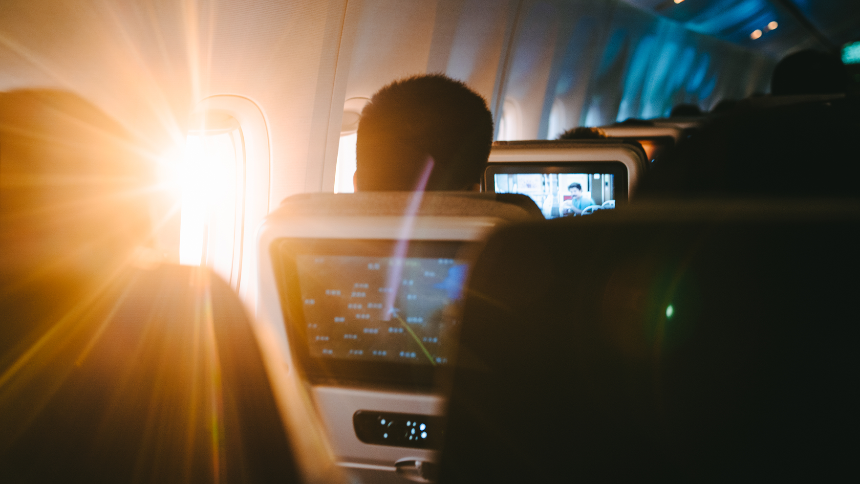Person enjoying a movie during a flightwith the sun shinning on the window