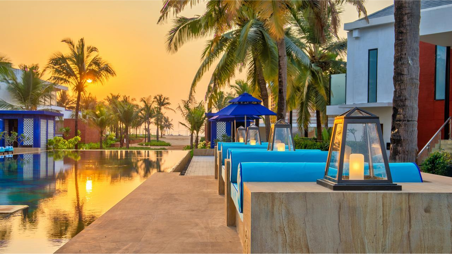 Tranquil resort dock by the water, lined with palm trees and bathed in golden sunset light
