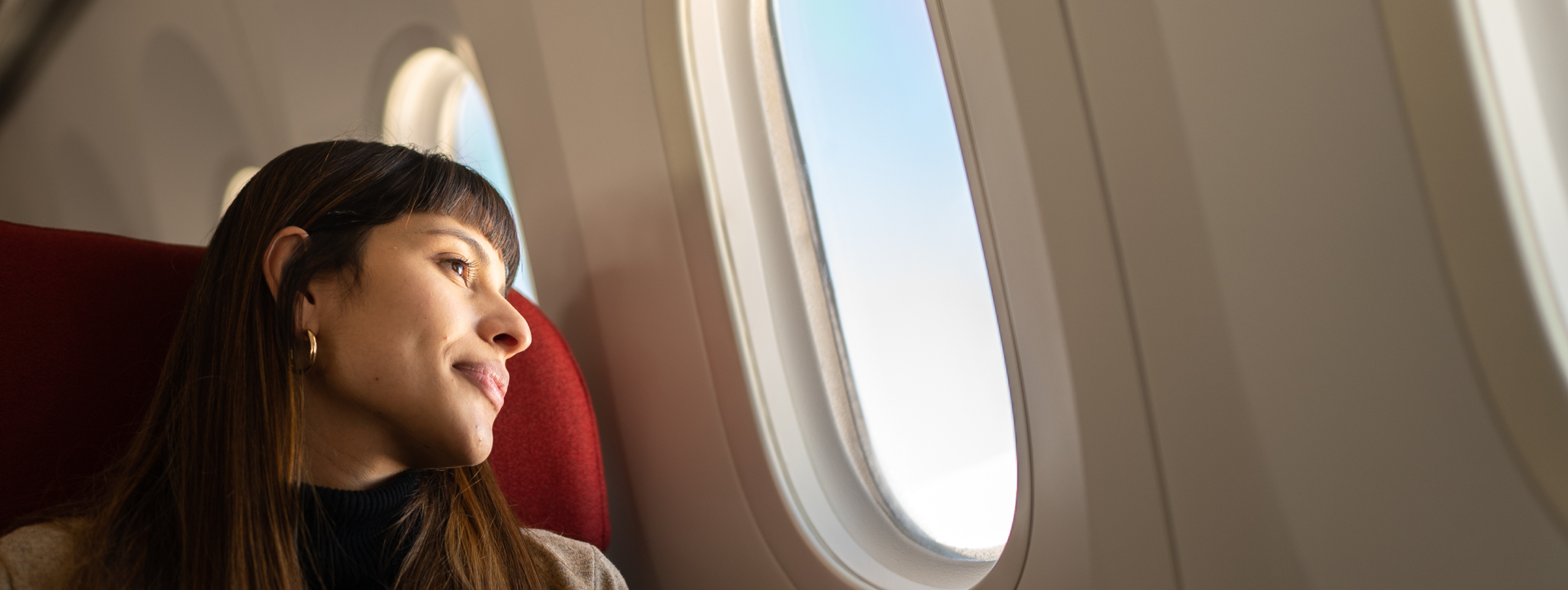 A young woman looking through an airplane window