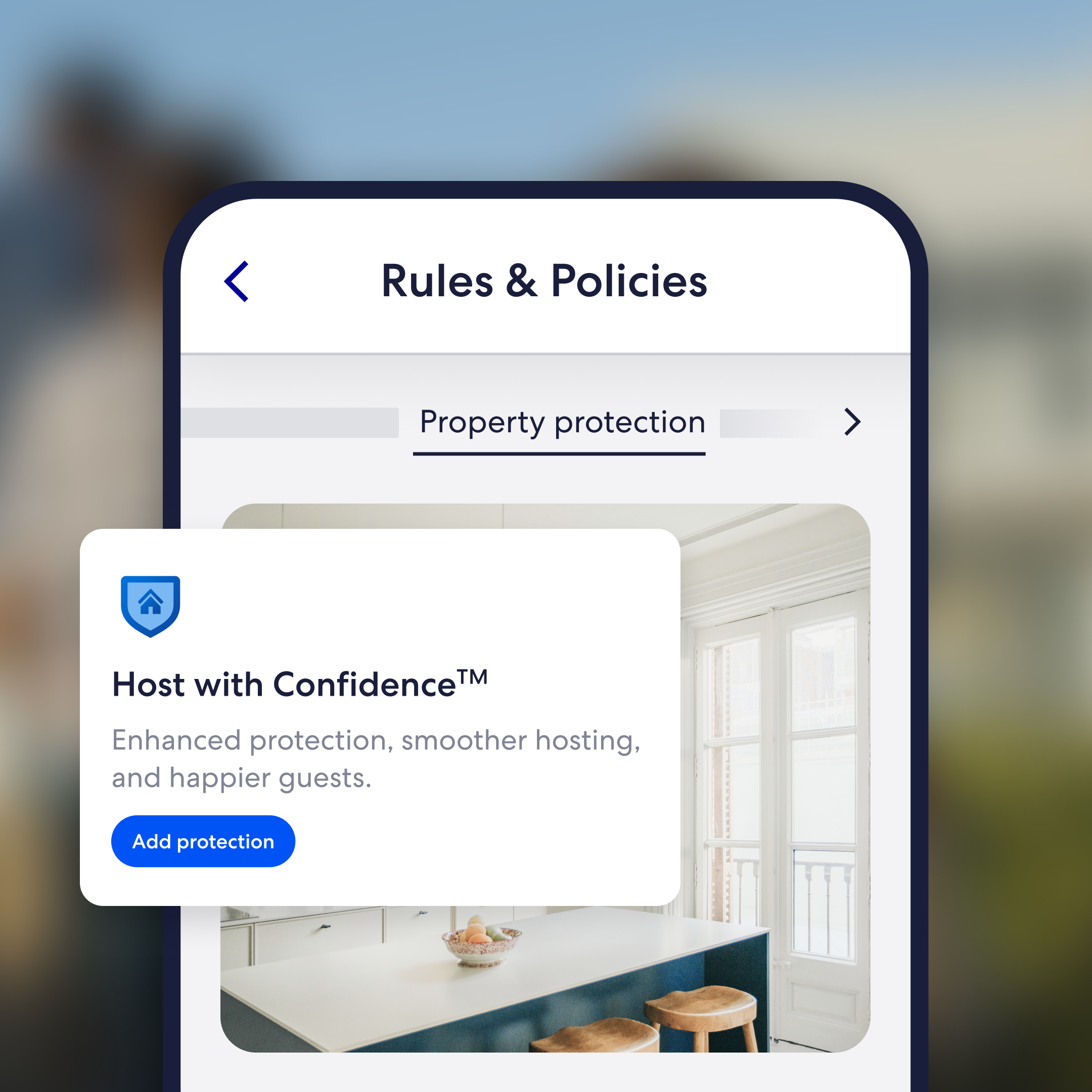 Smartphone displaying the Vrbo host Rules & Policies page with a Property protection section. A 'Host with Confidence™' card promotes enhanced protection, smoother hosting, and happier guests, with an 'Add protection' button. A modern kitchen interior is visible in the background listing image.